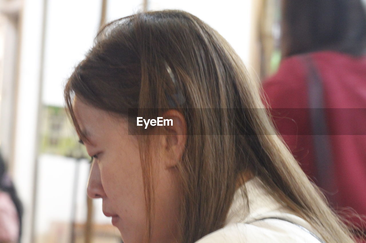 adult, headshot, women, portrait, person, looking, young adult, emotion, focus on foreground, close-up, female, side view, hairstyle, indoors, two people, long hair, lifestyles, day, brown hair, teenager, profile view, human face, togetherness, contemplation, human hair, window