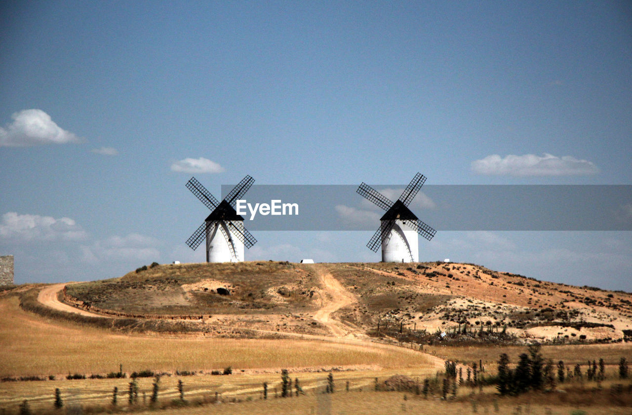 Traditional windmill on field against sky