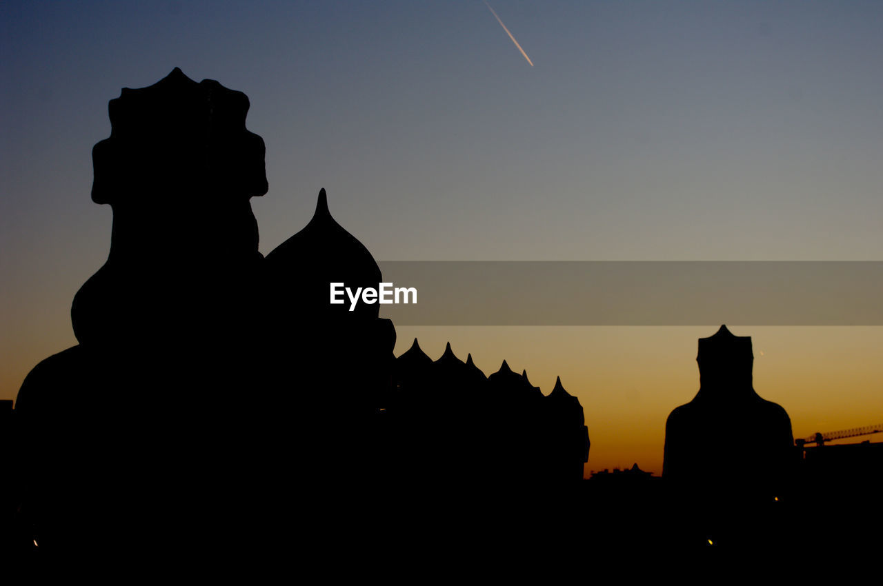 SILHOUETTE OF STATUE AGAINST SKY AT SUNSET