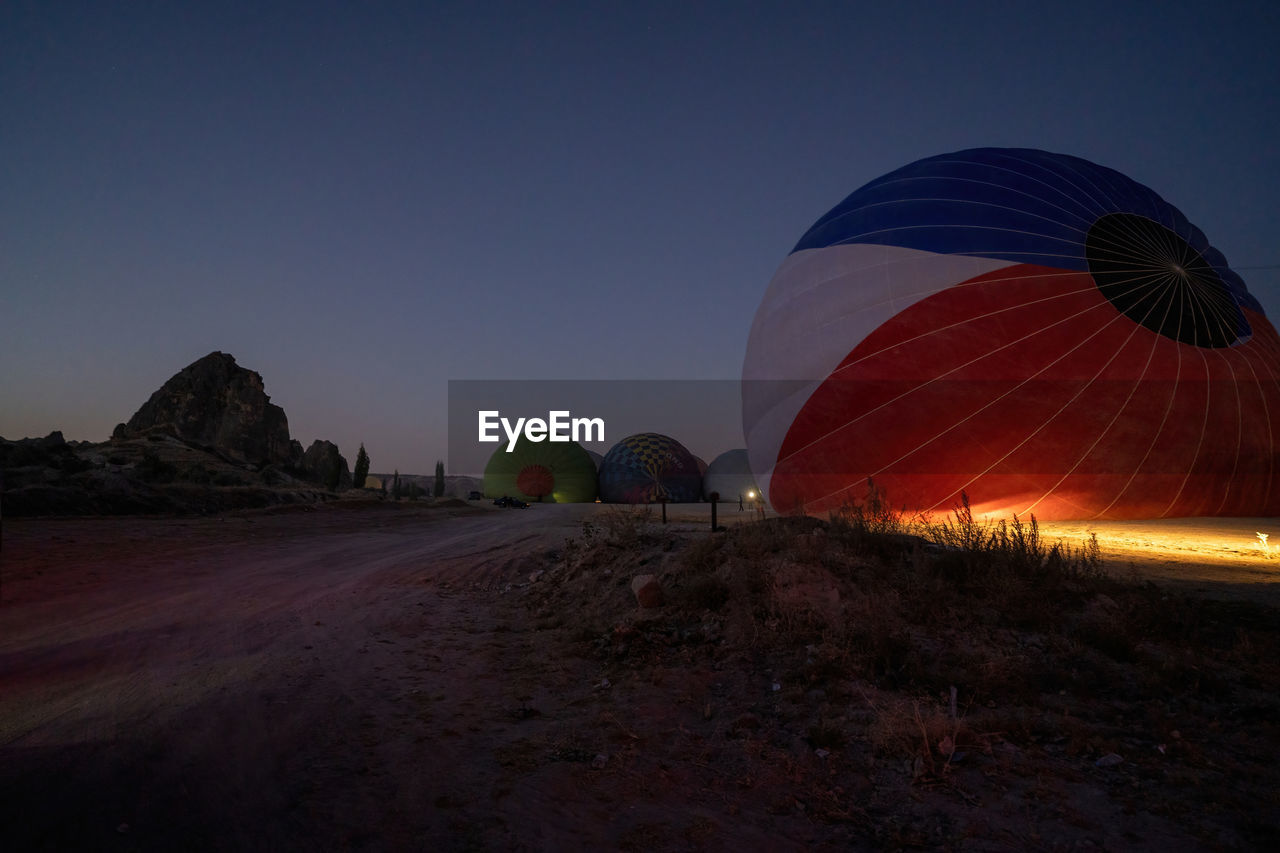 Air hot air balloons being filled with helium gas at night before flight  in cappadocia, turkey