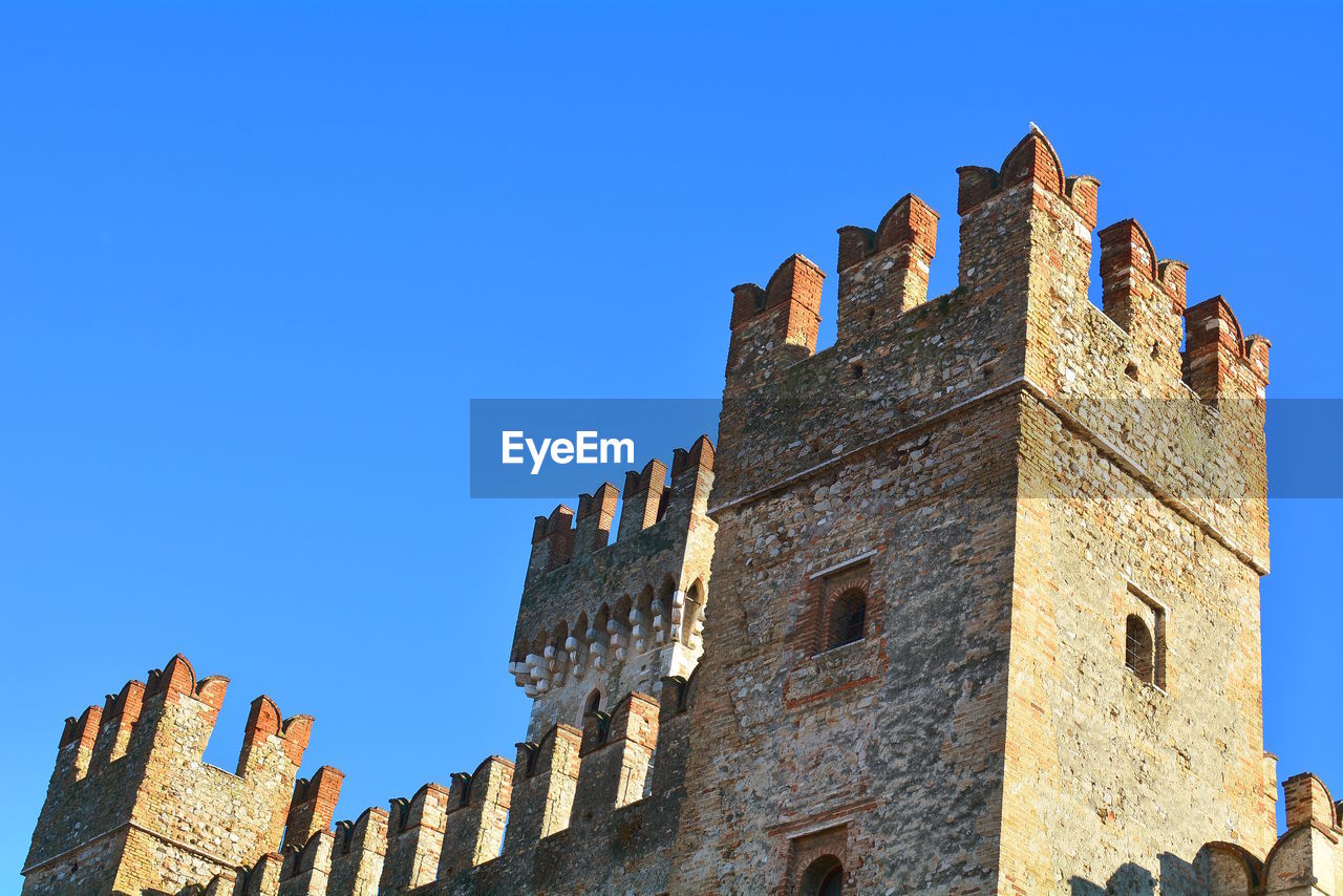 Low angle view of historic building against blue sky
