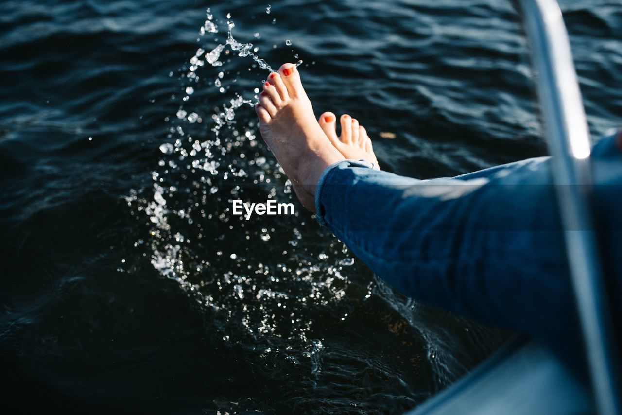 Low section of woman splashing water