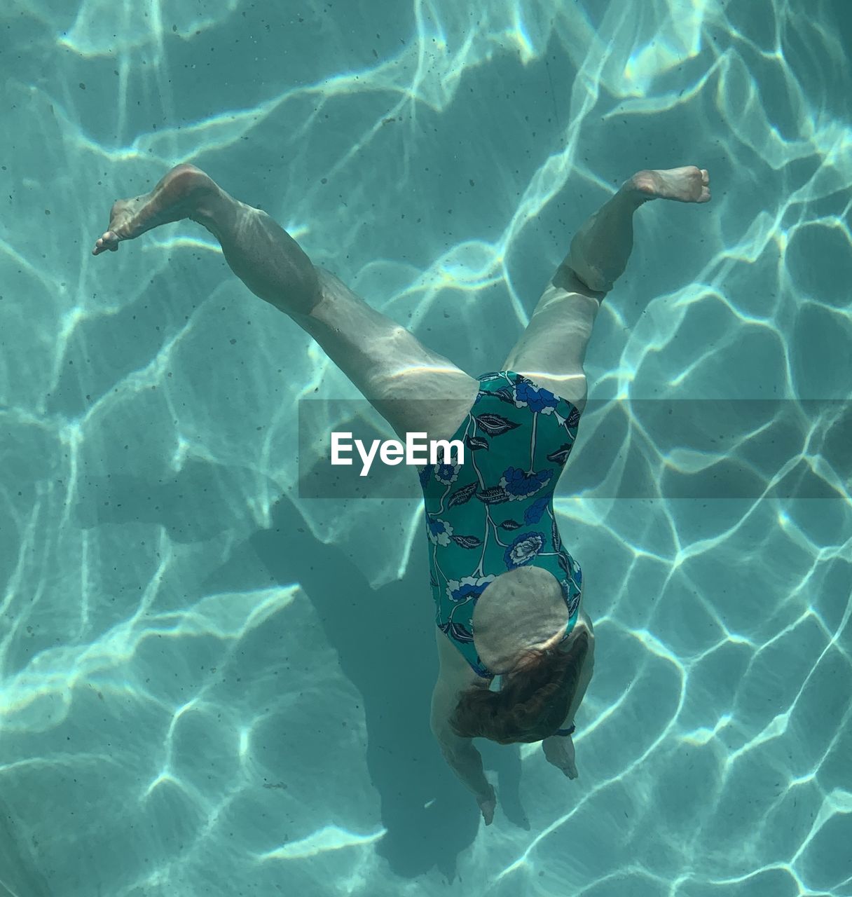 HIGH ANGLE VIEW OF WOMAN SWIMMING IN POOL