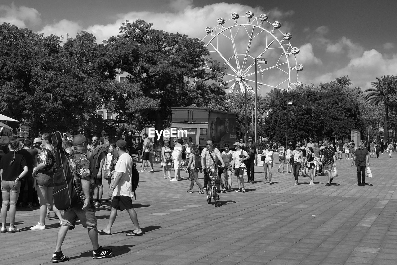 People walking on footpath during sunny day