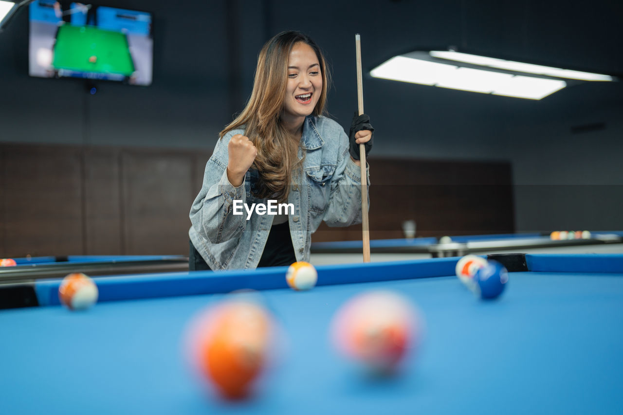 midsection of woman playing pool at home