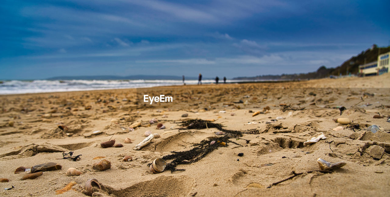 SURFACE LEVEL OF BEACH AGAINST SKY