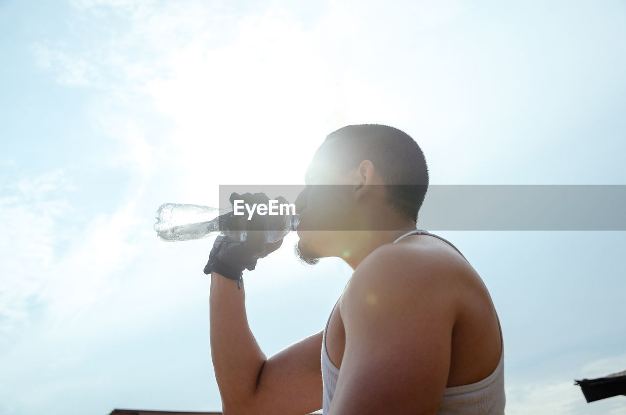 MAN PHOTOGRAPHING AGAINST SKY