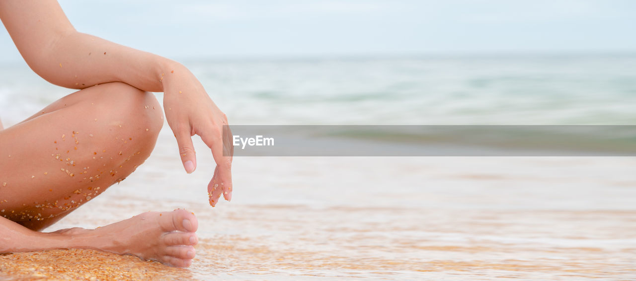 Panoramic close-up image of the legs and arms of a caucasian young woman. sits relaxing in lotus