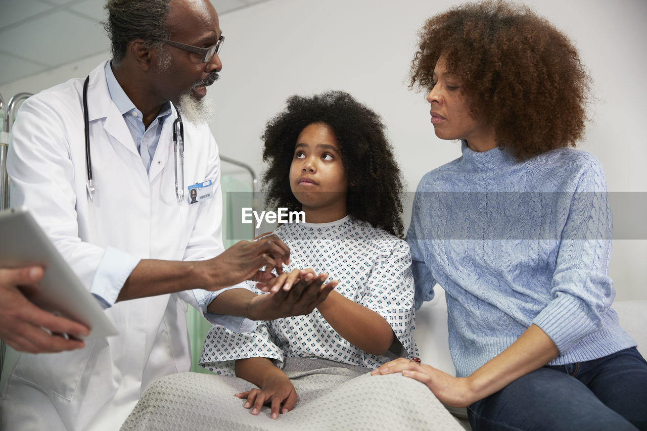Doctor explaining recovery status to patient's mother at hospital