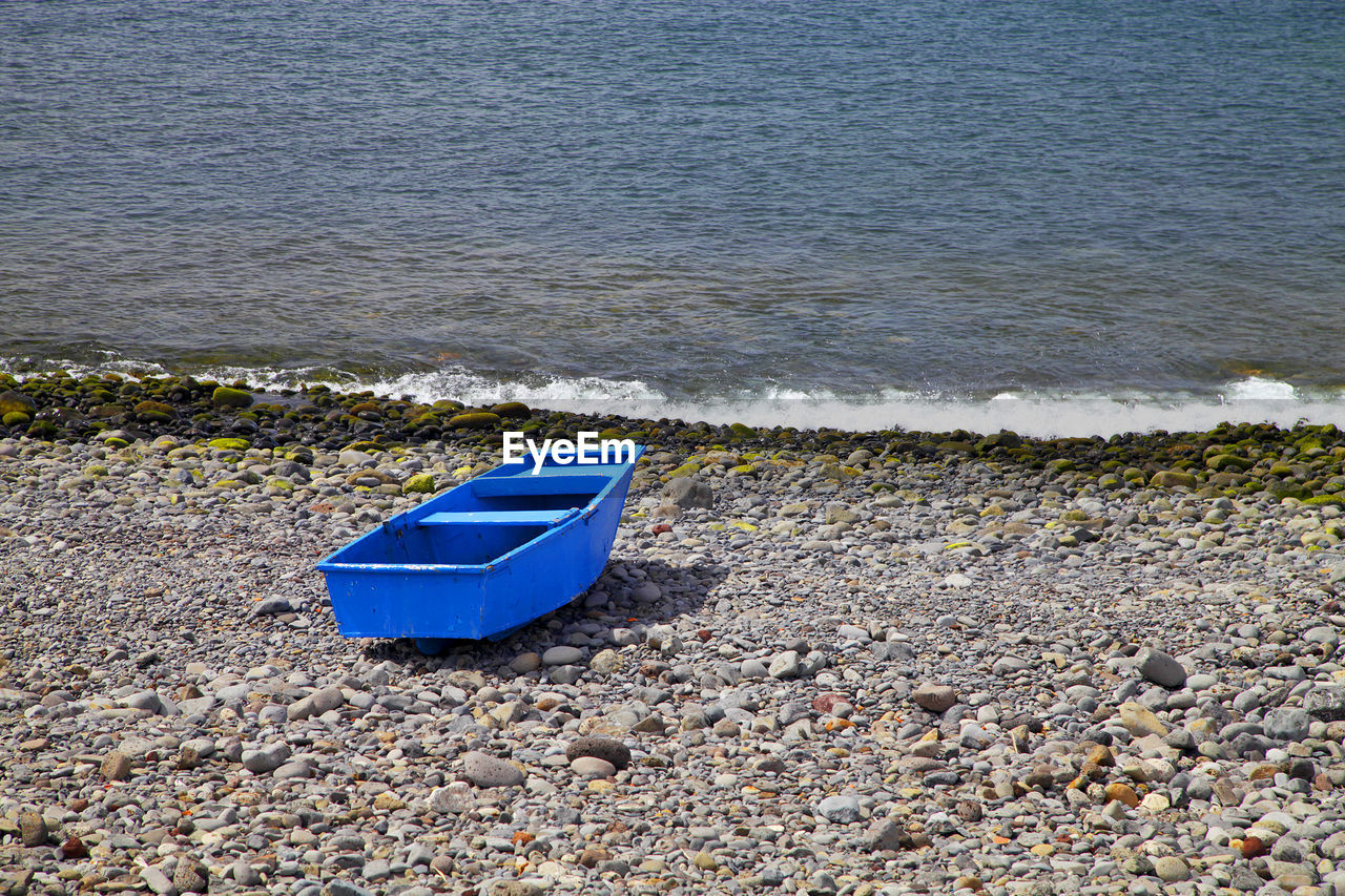 Blue boat on shore at beach