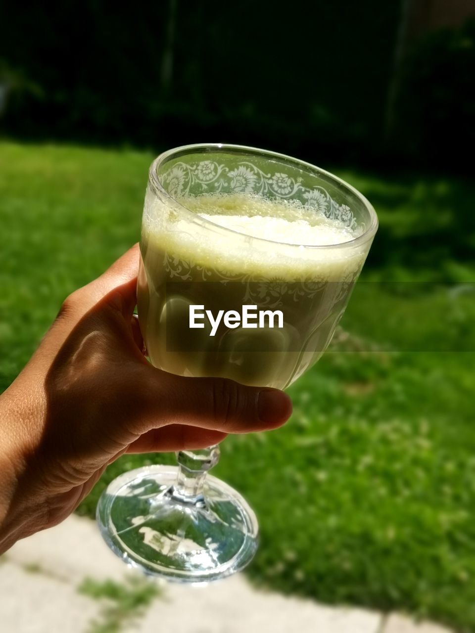 CLOSE-UP OF HAND HOLDING DRINK IN GLASS