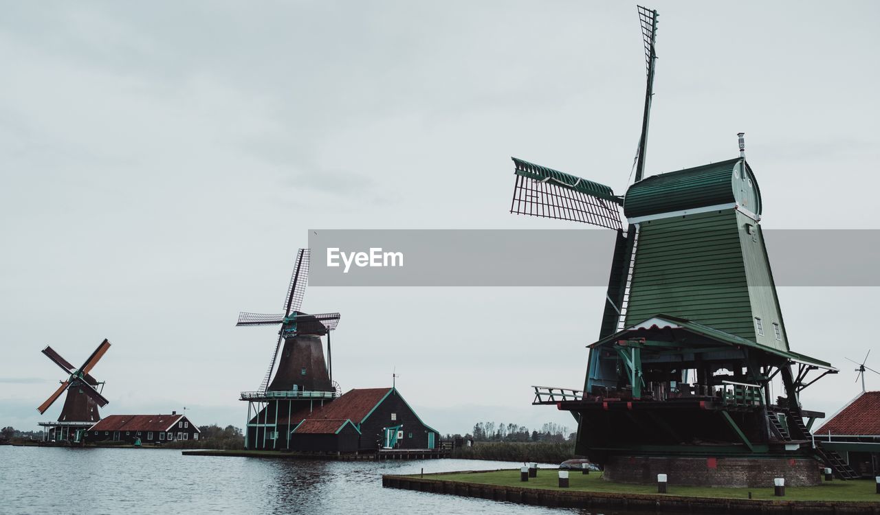 windmill, wind power, renewable energy, wind turbine, water, turbine, mill, architecture, alternative energy, sky, environmental conservation, power generation, nature, environment, built structure, machine, traditional windmill, no people, vehicle, nautical vessel, transportation, day, sea, building exterior, outdoors, industry, wind, cloud, building, landscape, history, business finance and industry