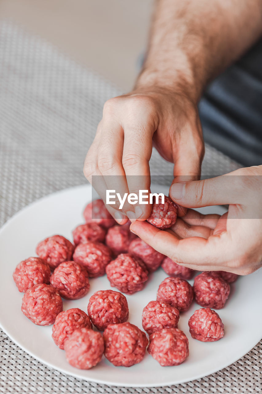 CLOSE-UP OF HAND HOLDING STRAWBERRY