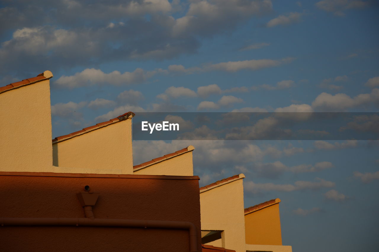 LOW ANGLE VIEW OF BUILDINGS AGAINST SKY DURING SUNSET