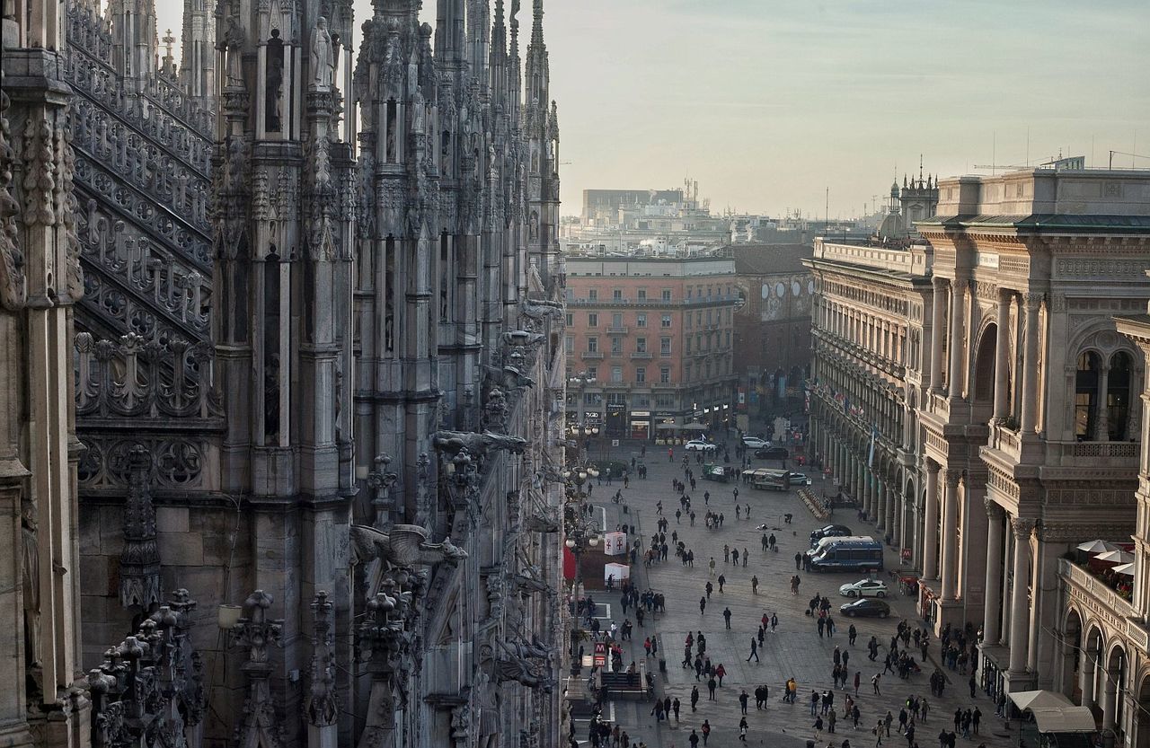 People on street by duomo di milano against sky