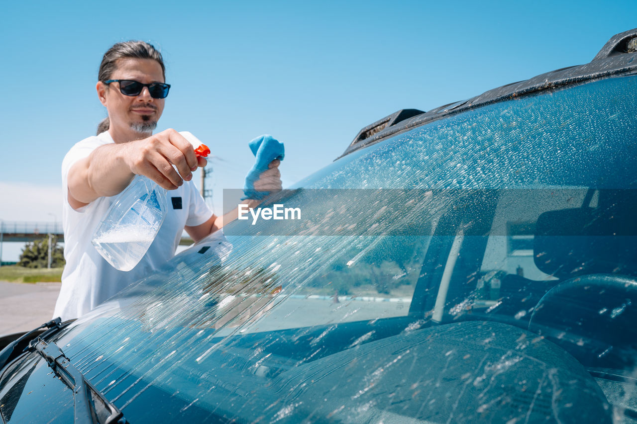 Man washing car windshield