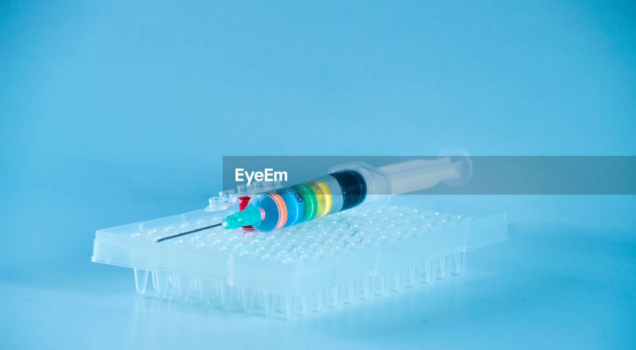 blue, healthcare and medicine, studio shot, blue background, colored background, medicine, indoors, copy space, no people, science, syringe, medical supplies, needle, research, close-up, technology, dose