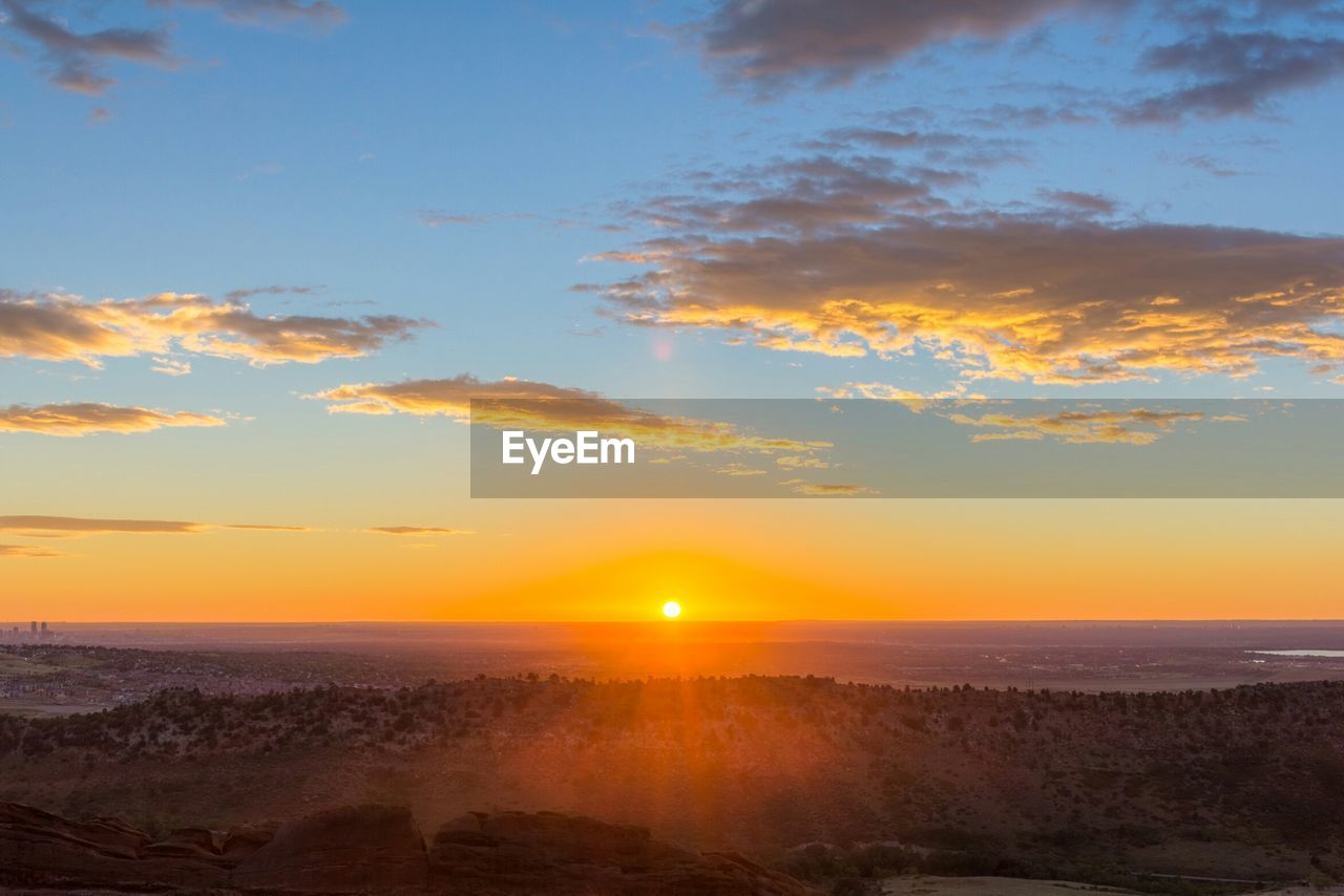 Scenic view of landscape against sky at sunrise