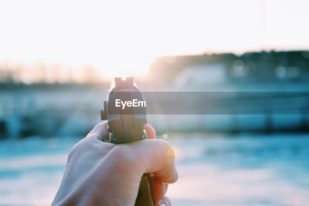 Cropped image of person holding gun