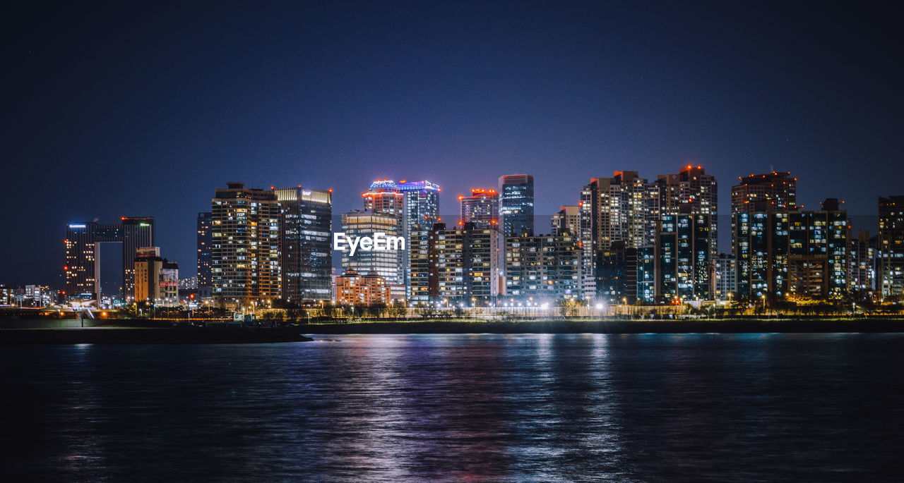 ILLUMINATED BUILDINGS IN CITY AT NIGHT