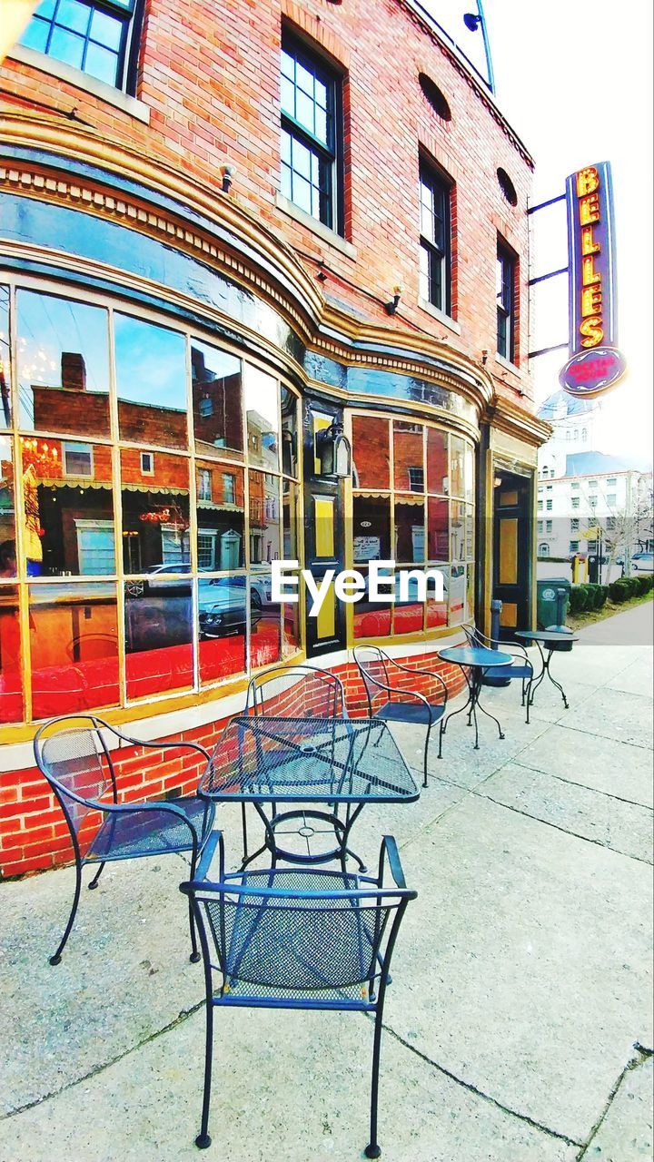 CHAIRS AGAINST BUILDINGS IN CITY