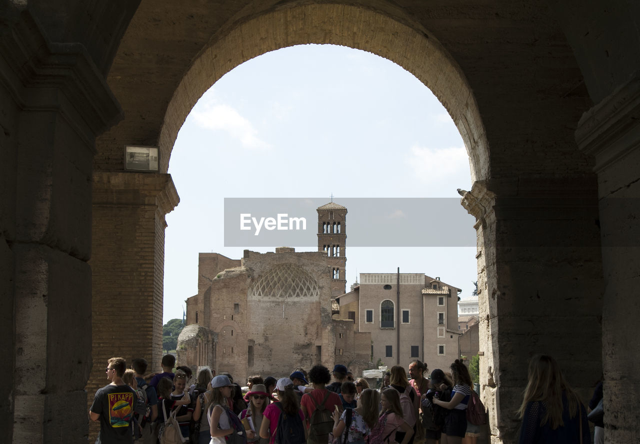 People in historic building against sky