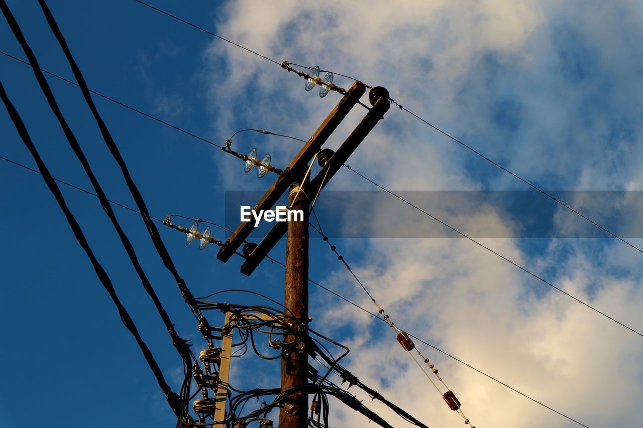 Low angle view of electricity pylon against sky