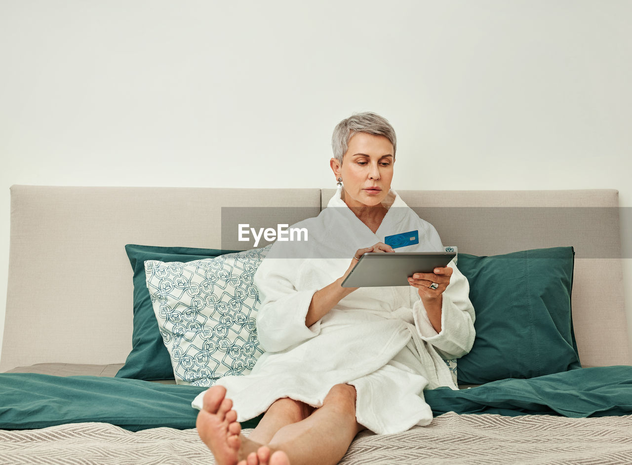 Young man using mobile phone while sitting on sofa