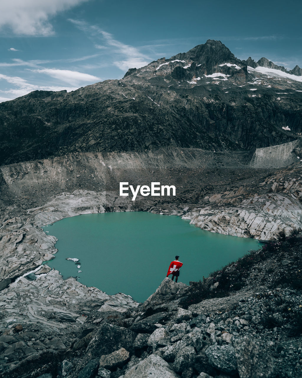 High angle view of man on mountain by lake