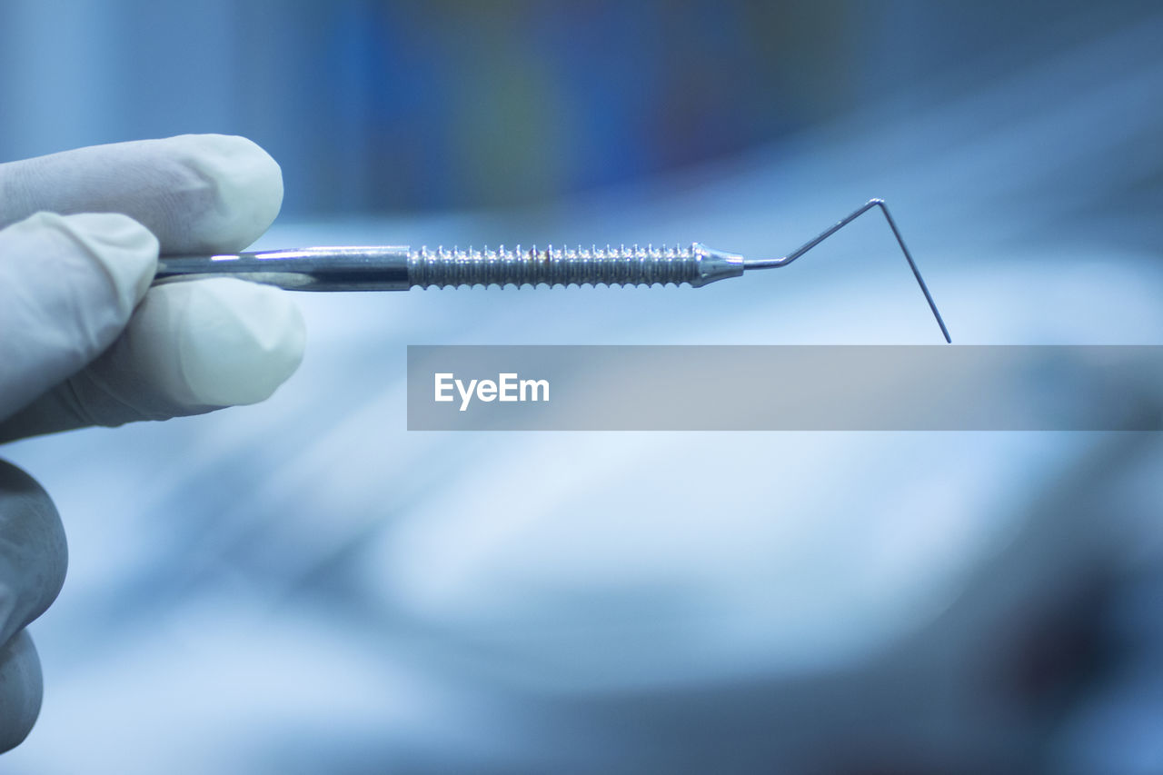 Cropped hand of dentist holding dental equipment