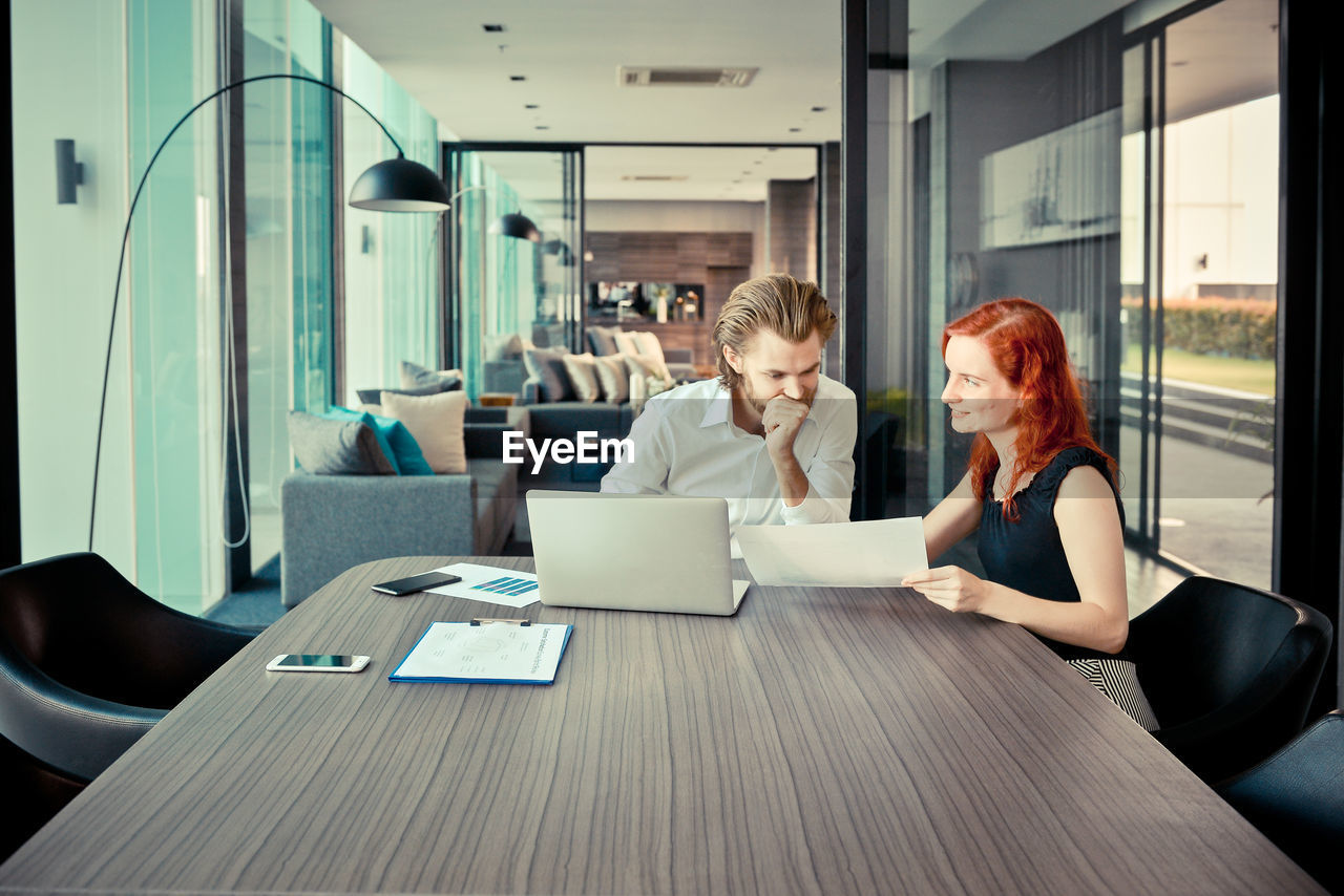 WOMAN WORKING WITH LAPTOP IN OFFICE