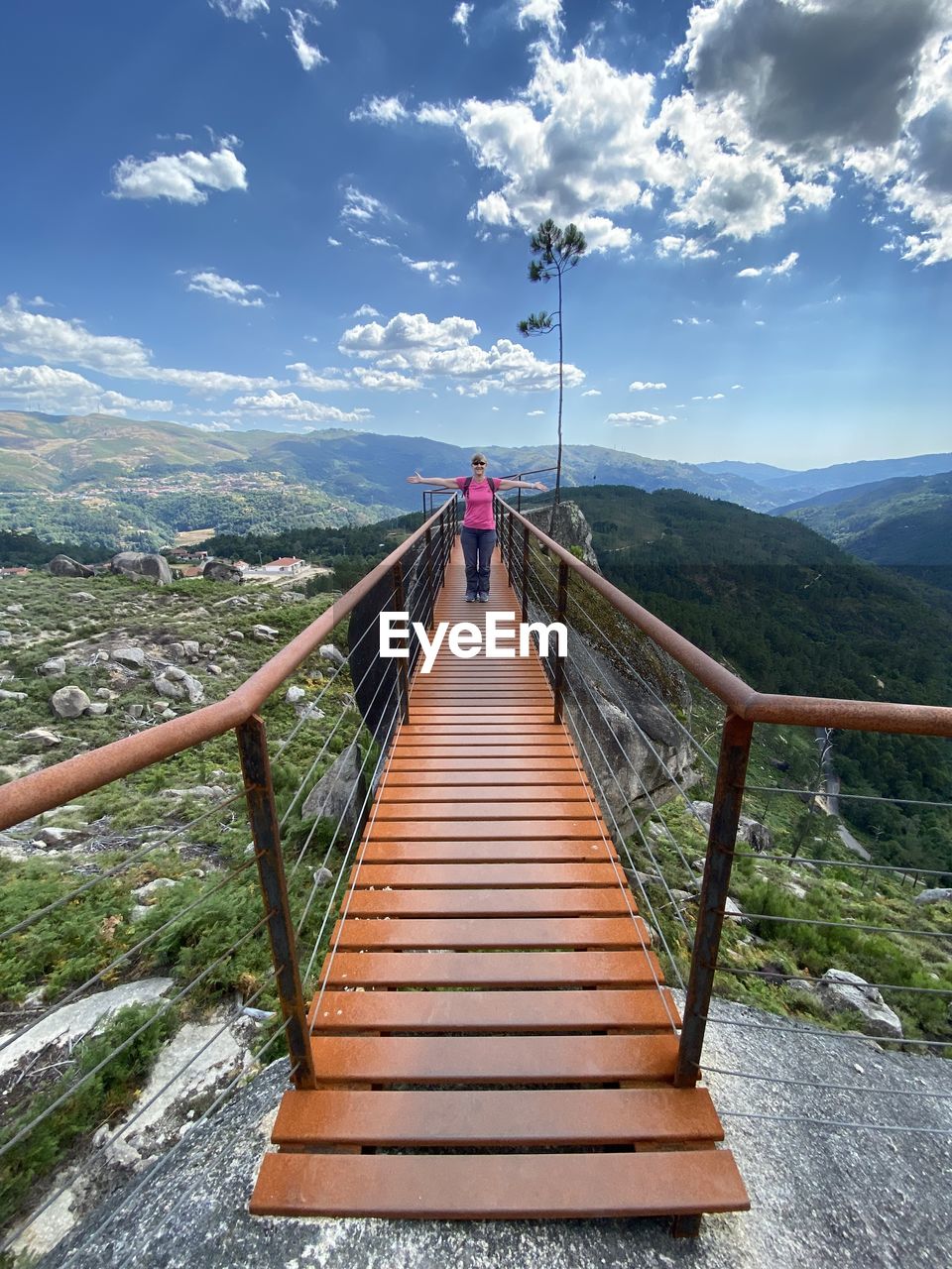 Full length of woman walking on footbridge over landscape