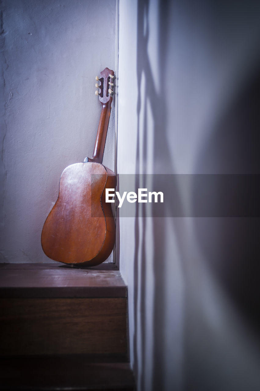 Acoustic guitar on wooden staircase at home