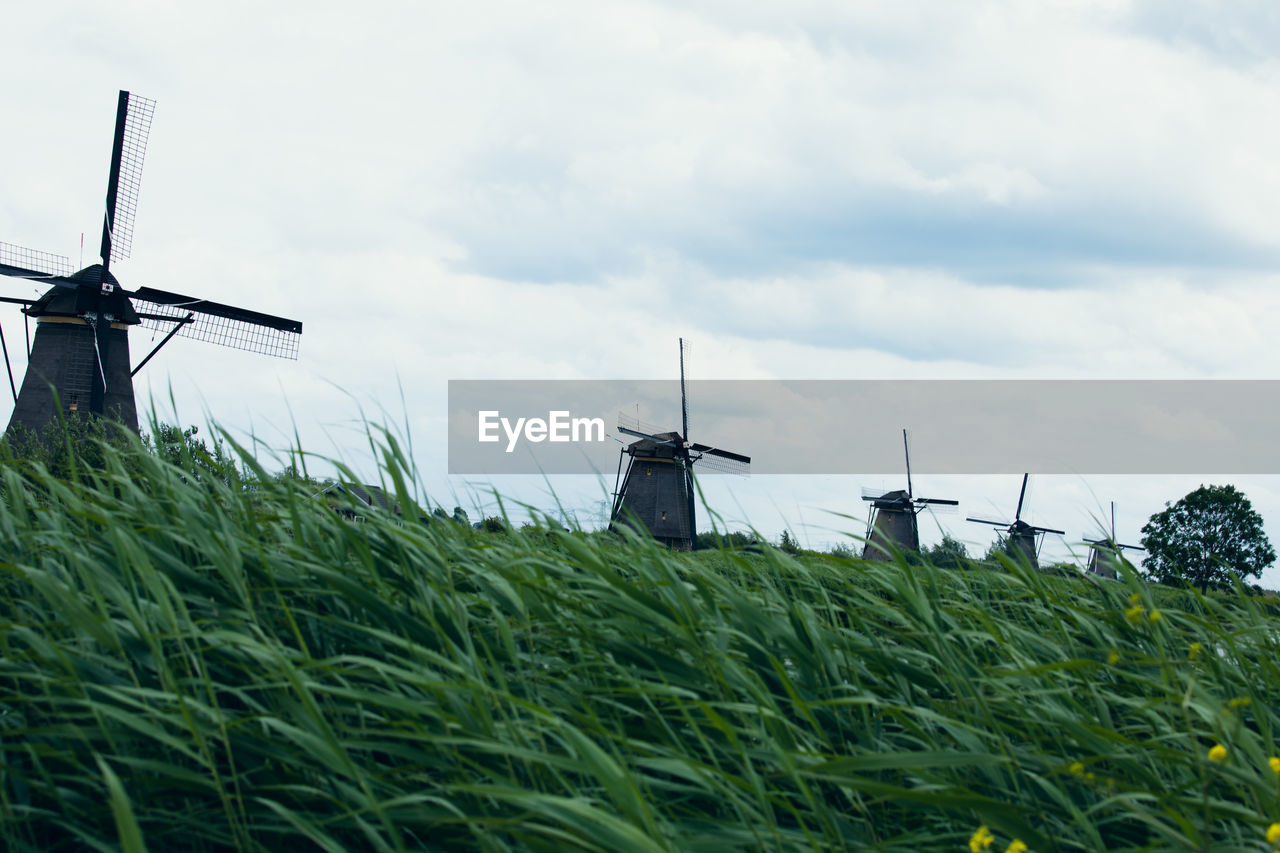 Traditional windmill on field against sky