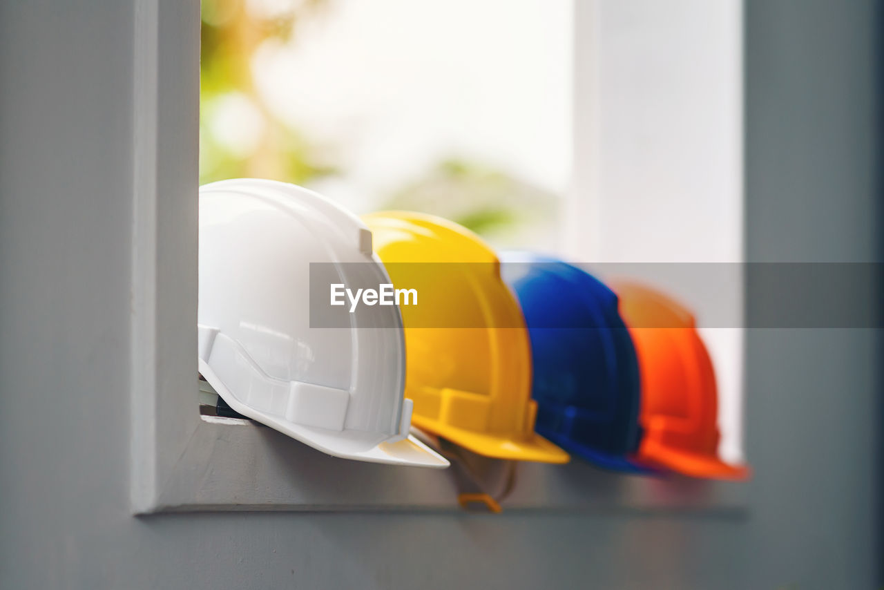 White, yellow and other colored safety helmets for workers' safety projects in the position 