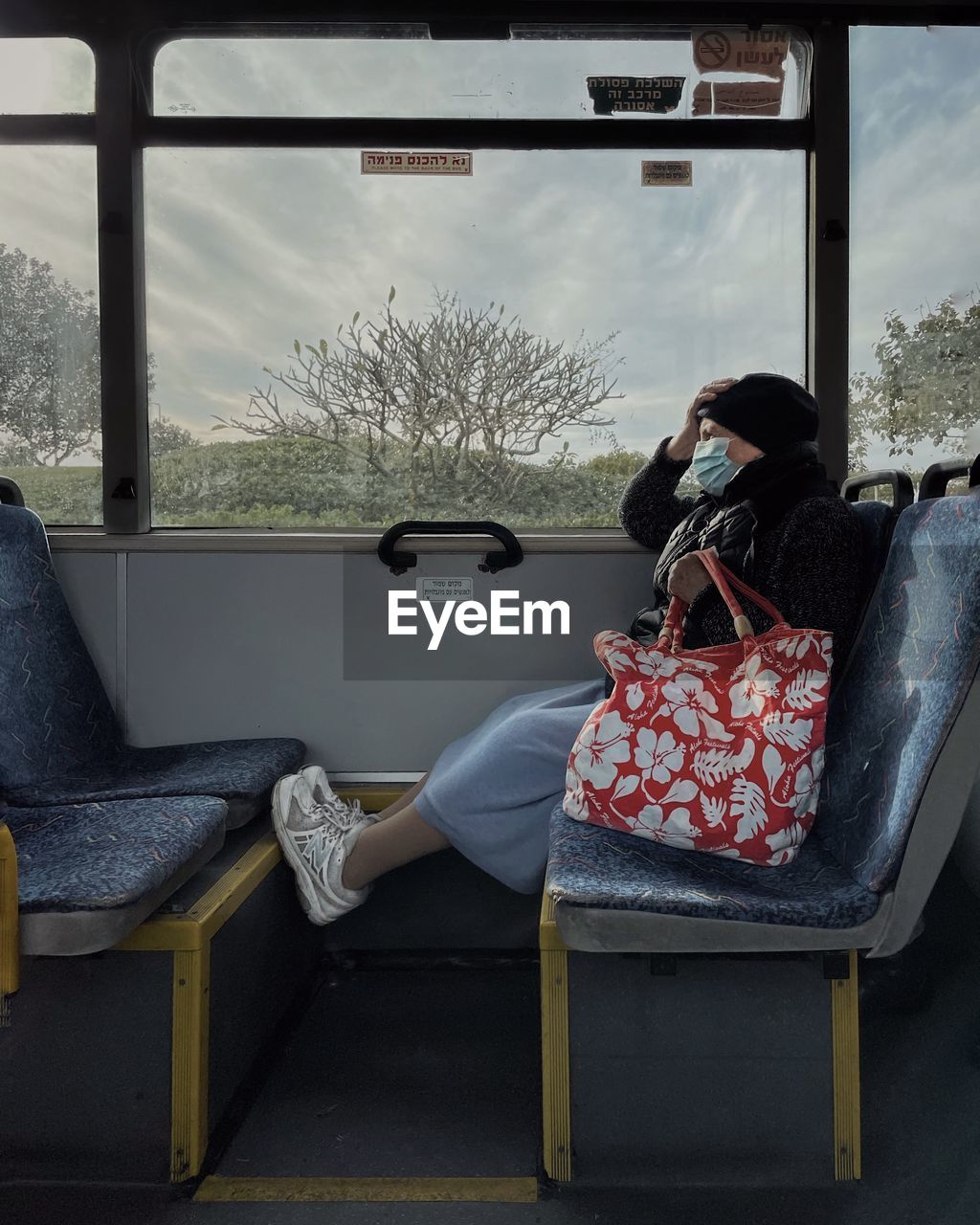 REAR VIEW OF MAN SITTING ON SEAT IN TRAIN