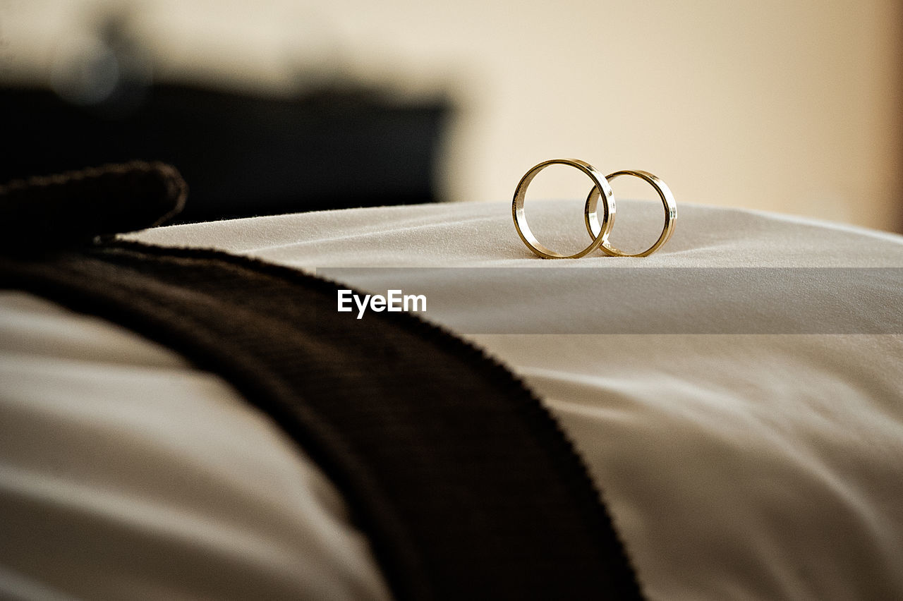 Close-up of wedding rings on pillow