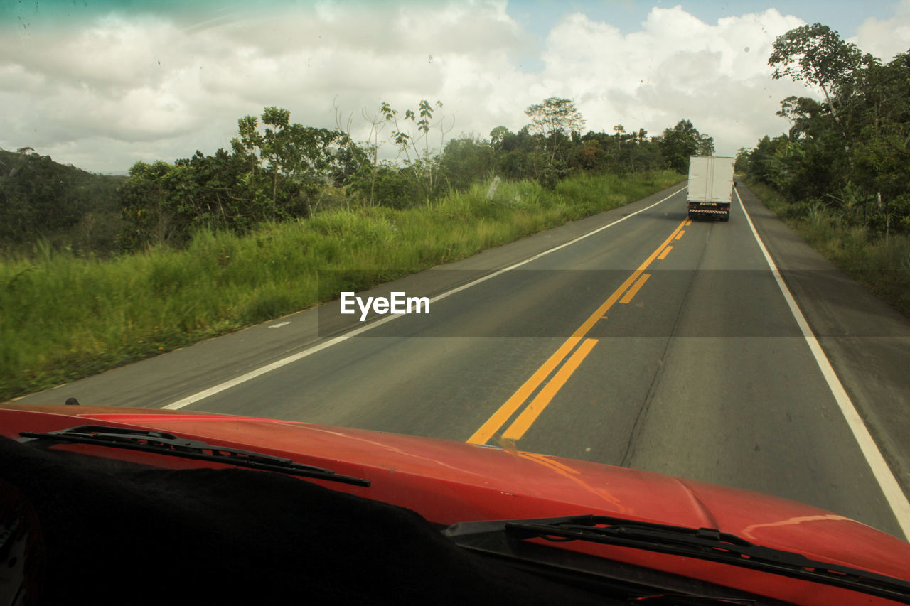 Vehicle on road seen through car windshield