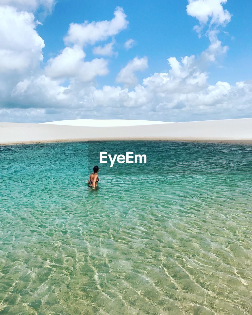 Young woman in sea against sky