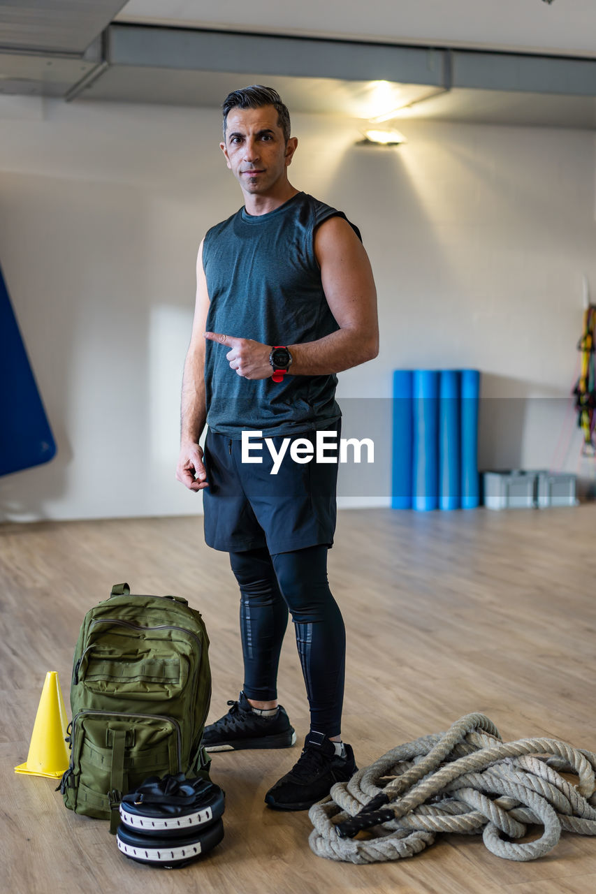 Full length portrait of man standing against wall