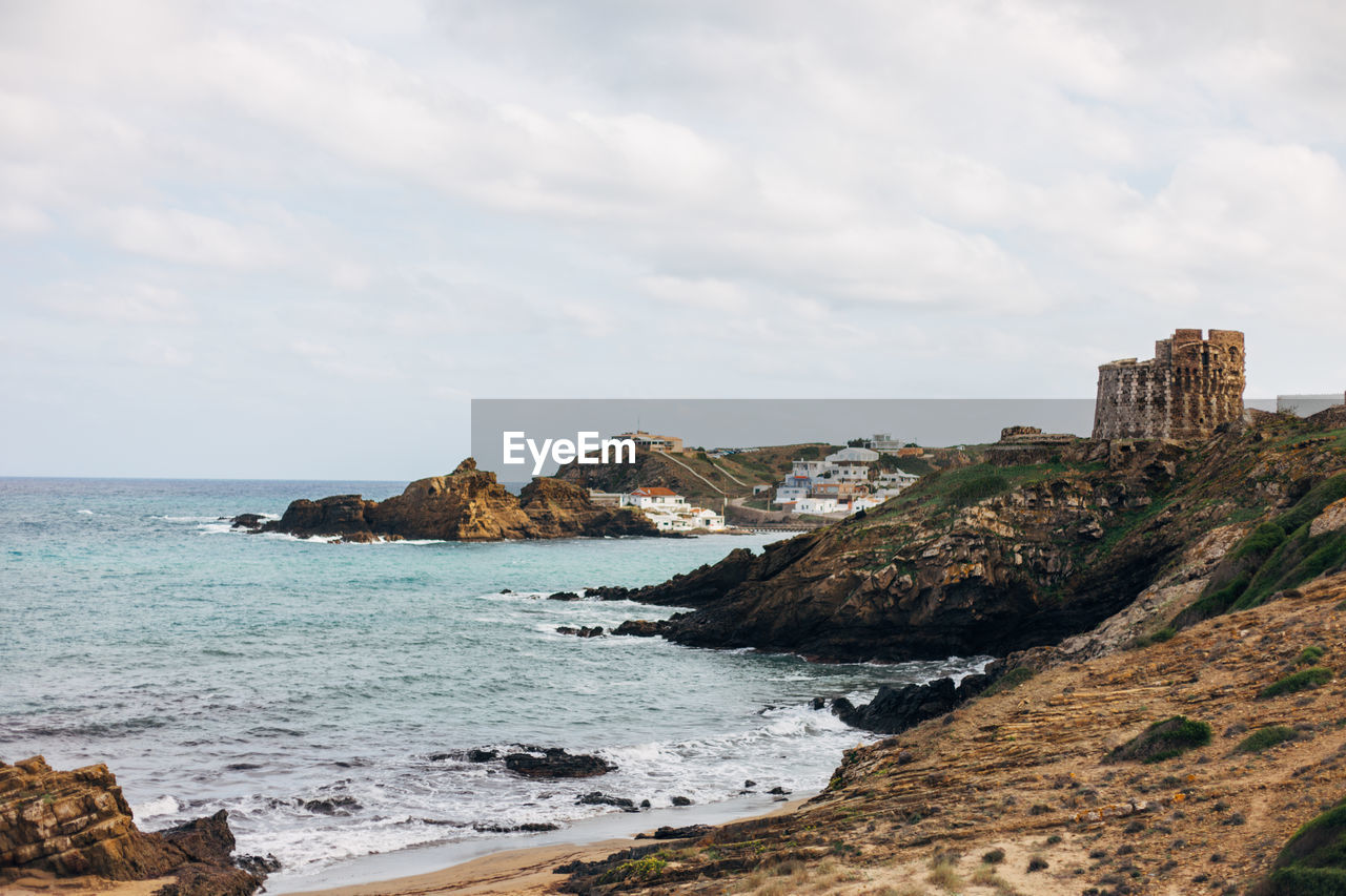 SCENIC VIEW OF SEA BY ROCKS AGAINST SKY