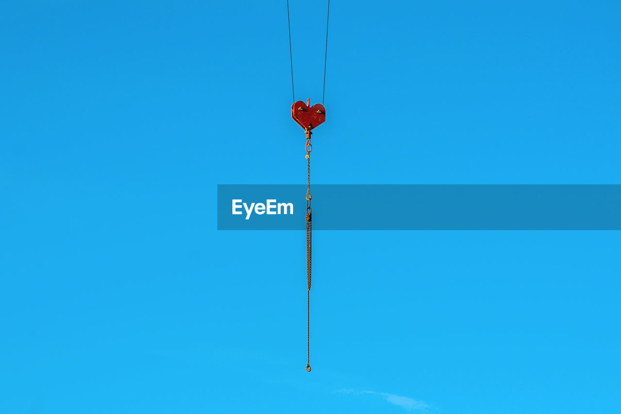 Low angle view of telephone pole against clear blue sky