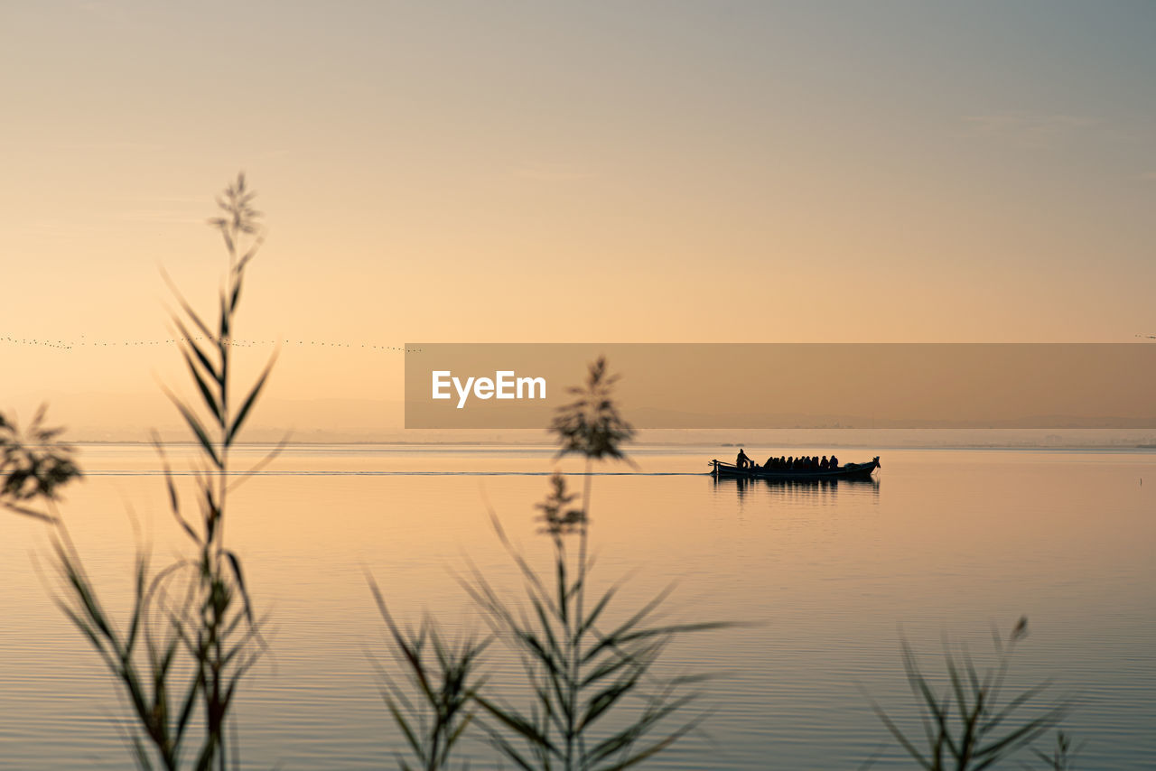 Boat in valencia's albufera at sunset against the light