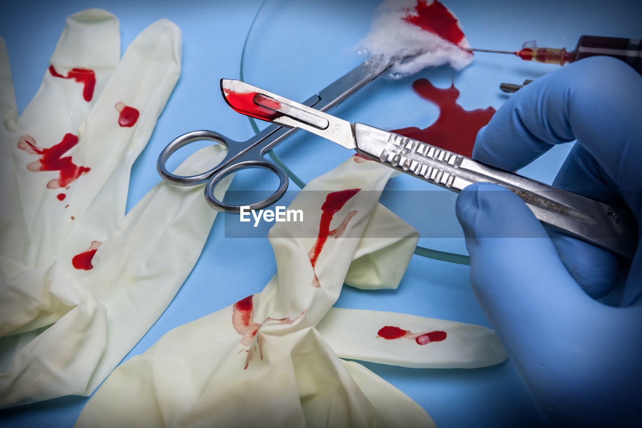 High angle view of hand holding medical equipment on table