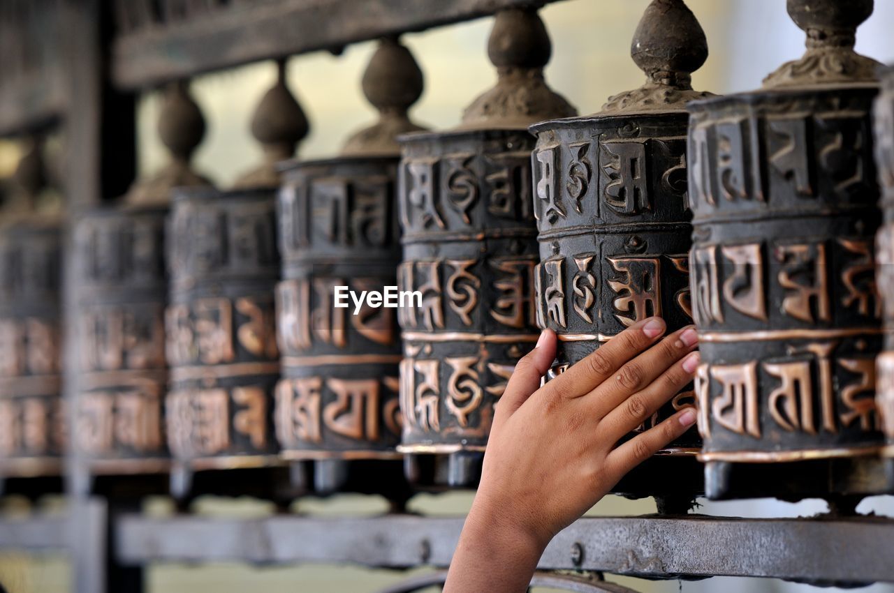 Cropped image of person touching prayer wheel