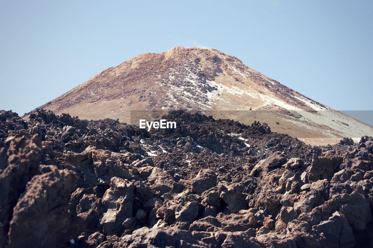 Scenic view of mountains against clear blue sky