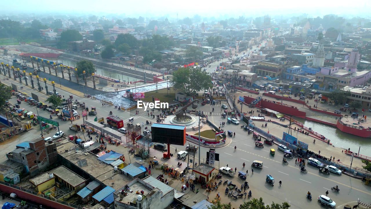 architecture, city, high angle view, built structure, building exterior, transportation, crowd, bird's-eye view, aerial photography, mode of transportation, street, cityscape, car, building, road, motor vehicle, nature, town, metropolitan area, traffic, aerial view, city life, land vehicle, city street, residential area, outdoors, sky, day, residential district, travel destinations, neighbourhood, crowded, group of people, large group of people, travel, metropolis, landscape, roof