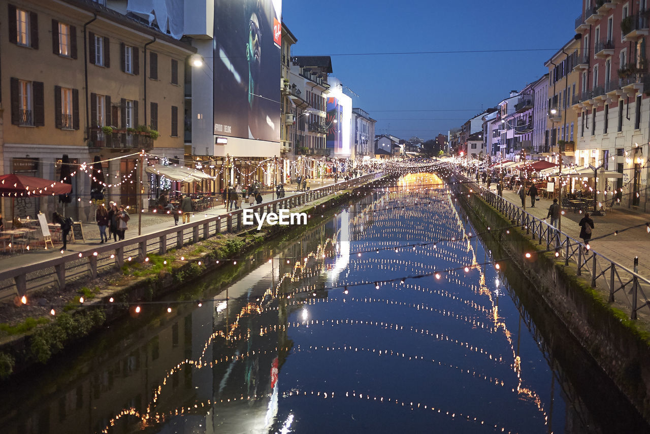 Aerial view of illuminated street amidst buildings in city at night