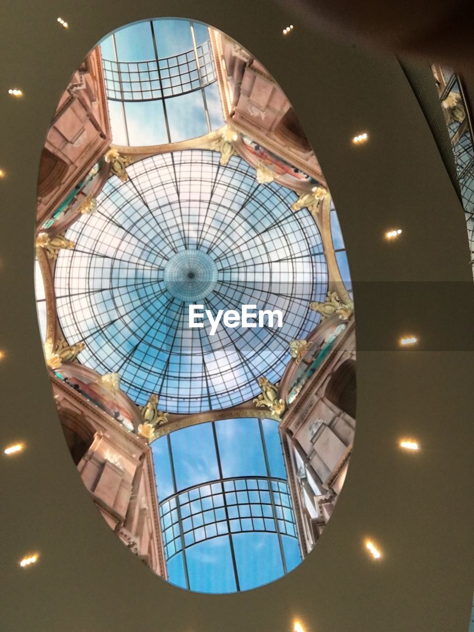 LOW ANGLE VIEW OF ILLUMINATED CHANDELIER AT SHOPPING MALL