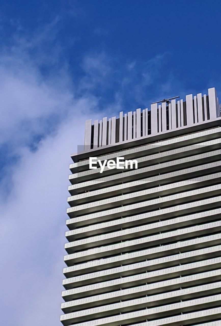 LOW ANGLE VIEW OF MODERN BUILDING AGAINST BLUE SKY